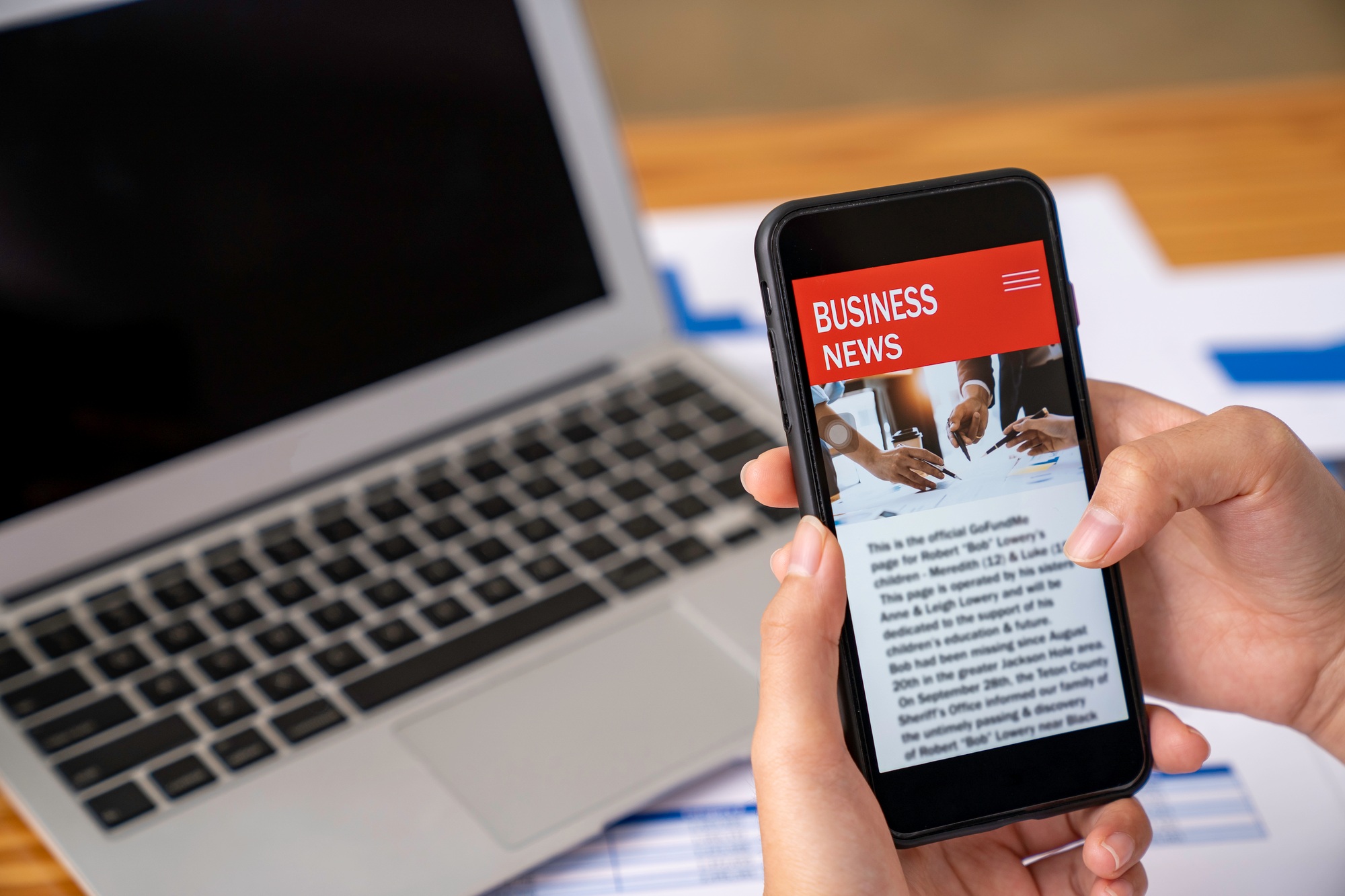 business woman using a mobile phone in the office to update financial investment news and analysis o