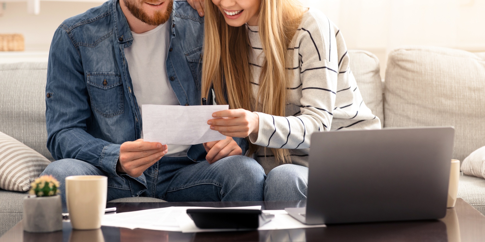 Happy married couple looking at personal finances at home